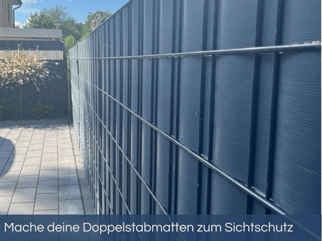 Anthrazitfarbener Doppelstabmattenzaun mit eingeflochtenem, gerilltem Sichtschutz für modernen Sichtschutz im Außenbereich.
